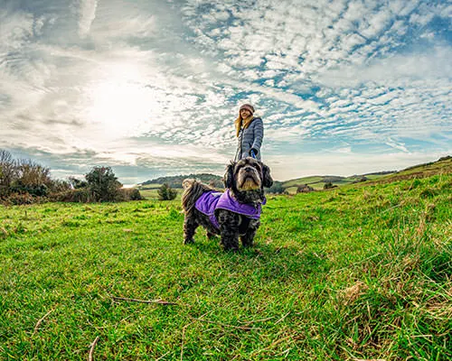 a woman and a small dog standing at mottistone down isle of wight